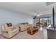 Inviting living room featuring neutral paint, ceiling fan and access to the balcony at 25100 Sandhill Blvd # V202, Punta Gorda, FL 33983