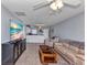 Open-concept living area with tile floors, ceiling fan, and a modern flat-screen television at 25100 Sandhill Blvd # V202, Punta Gorda, FL 33983