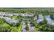 Aerial view of a neighborhood with a community pool, pond, lush trees, and well-maintained landscaping at 26548 Castleview Way, Wesley Chapel, FL 33544