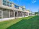 Townhome backyard with a lush green lawn and screened patio at 26548 Castleview Way, Wesley Chapel, FL 33544
