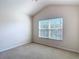 This cozy carpeted bedroom has a high ceiling and a large window that lets in plenty of natural light at 26548 Castleview Way, Wesley Chapel, FL 33544