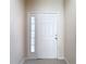 A welcoming foyer featuring neutral colored walls and a front door with sidelight at 26548 Castleview Way, Wesley Chapel, FL 33544