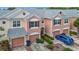Charming townhome featuring a two-car garage, brick-paver driveway, and lush landscaping at 26548 Castleview Way, Wesley Chapel, FL 33544