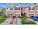 Charming townhome showcasing a two-car garage, well-manicured landscaping, and inviting curb appeal at 26548 Castleview Way, Wesley Chapel, FL 33544