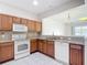Well-lit kitchen boasts stainless steel appliances, brown cabinets, and granite countertops, creating a warm, inviting space at 26548 Castleview Way, Wesley Chapel, FL 33544