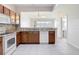 Well-lit kitchen featuring wood cabinetry, granite countertops, and tiled flooring at 26548 Castleview Way, Wesley Chapel, FL 33544