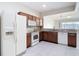 Bright kitchen with wood cabinets, white appliances, granite countertops, and tiled floor at 26548 Castleview Way, Wesley Chapel, FL 33544