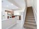 Kitchen and stairs featuring granite countertops, wood cabinets, white appliances, and neutral walls at 26548 Castleview Way, Wesley Chapel, FL 33544