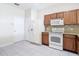 Spacious kitchen featuring wooden cabinetry, a white fridge, granite countertops, and tiled floor at 26548 Castleview Way, Wesley Chapel, FL 33544