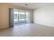 Bright living room with tile floors and sliding glass doors leading to a screened patio at 26548 Castleview Way, Wesley Chapel, FL 33544