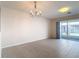 Open living space featuring tile floors, a chandelier, and sliding glass doors leading to outdoor area at 26548 Castleview Way, Wesley Chapel, FL 33544