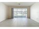 Living room with tile flooring and sliding glass doors that lead to an enclosed screened patio at 26548 Castleview Way, Wesley Chapel, FL 33544
