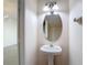 This powder room features a pedestal sink, an oval mirror, and modern lighting at 26548 Castleview Way, Wesley Chapel, FL 33544