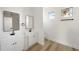 Bright bathroom with double vanity sinks, modern mirrors, and wood-look floors at 2813 Sally Ln, North Port, FL 34286
