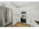Bright kitchen featuring stainless steel appliances, white cabinets, and modern countertops at 2813 Sally Ln, North Port, FL 34286