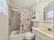 Bathroom featuring a floral shower curtain, neutral tile, mirror and vanity cabinet at 2818 Olympic St, Sarasota, FL 34231