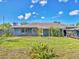 Rear exterior view of home featuring a chimney and door with green space in yard at 2818 Olympic St, Sarasota, FL 34231