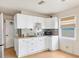 Efficient kitchen space with white cabinets, bright countertop, and a window for natural light at 2818 Olympic St, Sarasota, FL 34231