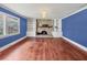 Living room with wood floors, blue walls, and a brick fireplace at 2818 Olympic St, Sarasota, FL 34231