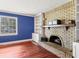 Living room with wood floors, blue walls, and a brick fireplace at 2818 Olympic St, Sarasota, FL 34231
