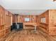 A view of the living room featuring wood paneling and a wood-burning stove at 2818 Olympic St, Sarasota, FL 34231
