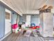 Damaged sunroom interior with wooden flooring and side door, showcasing renovation potential at 2818 Olympic St, Sarasota, FL 34231