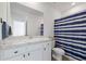 Bathroom featuring white cabinets, sink, mirror and blue striped shower curtain at 2824 Pearly Banks Dr, Bradenton, FL 34208