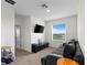 Cozy bedroom with a dark colored couch and a wall-mounted television for entertainment at 2824 Pearly Banks Dr, Bradenton, FL 34208