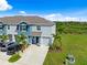 Two-story townhome boasts manicured landscaping, a one car garage, and a driveway with multiple parked cars at 2824 Pearly Banks Dr, Bradenton, FL 34208