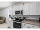 Bright kitchen featuring stainless steel appliances, granite countertops, and white cabinetry for a modern look at 2824 Pearly Banks Dr, Bradenton, FL 34208