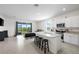 Open concept kitchen with white cabinets, granite counters, and a view to the patio and green space at 2824 Pearly Banks Dr, Bradenton, FL 34208