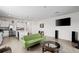 Open-concept living room with tile floors, a modern green sofa, and stainless steel kitchen appliances in background at 2824 Pearly Banks Dr, Bradenton, FL 34208