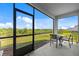 Covered, screened patio with outdoor dining set and green space views at 2824 Pearly Banks Dr, Bradenton, FL 34208