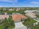 Beautiful aerial view of a beige single Gathering home with a tile roof, landscaped yard, and three car garage at 2937 Seasons Blvd, Sarasota, FL 34240