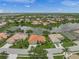 Aerial view of a single-Gathering home with red tile roof, a lake view, and lush landscaping in a gated community at 2937 Seasons Blvd, Sarasota, FL 34240