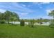 Lush backyard featuring a serene lake, manicured lawn and landscaping that enhances the home's appeal at 2937 Seasons Blvd, Sarasota, FL 34240