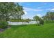 Picturesque backyard with mature trees, lake views, and well-maintained green lawn at 2937 Seasons Blvd, Sarasota, FL 34240