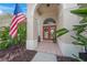 Close-up view of a covered front entry featuring a tiled porch and a decorative wreath hanging on the double front doors at 2937 Seasons Blvd, Sarasota, FL 34240