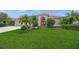 Inviting single-story home featuring a manicured lawn, mature palm trees, colorful flower beds and a front-entry two-car garage at 2937 Seasons Blvd, Sarasota, FL 34240