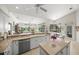Bright, open kitchen featuring an island, tile countertops, white cabinets, and a seamless transition to the eating area at 2937 Seasons Blvd, Sarasota, FL 34240