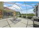 Screened-in patio featuring a dining set and picturesque lake views, perfect for outdoor entertaining at 2937 Seasons Blvd, Sarasota, FL 34240