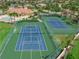 Aerial view of two tennis courts in a community setting with nearby houses and landscaping at 2937 Seasons Blvd, Sarasota, FL 34240