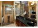 Luxurious bathroom featuring a walk-in shower, dual sinks with granite countertops, and decorative wallpaper at 2962 Wilderness E Blvd, Parrish, FL 34219