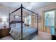 Bedroom features a four poster bed, chandelier, and bright window at 2962 Wilderness E Blvd, Parrish, FL 34219