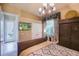 Bedroom showcasing a chandelier, large window, and mounted television for entertainment at 2962 Wilderness E Blvd, Parrish, FL 34219