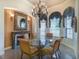 Dining room featuring a fireplace, a glass table, elegant chairs, and a decorative chandelier at 2962 Wilderness E Blvd, Parrish, FL 34219