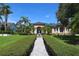 Elegant home featuring lush landscaping, a brick walkway, a fountain, and charming architectural details at 2962 Wilderness E Blvd, Parrish, FL 34219