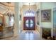 Elegant foyer with marble floors, a decorative wooden front door, chandelier, and an ornate painting at 2962 Wilderness E Blvd, Parrish, FL 34219