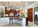 Kitchen area with dark wood cabinets, granite countertops, stainless steel appliances, and barstool seating at 2962 Wilderness E Blvd, Parrish, FL 34219