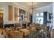 Luxurious living room featuring a stone fireplace, elegant seating, a chandelier, and large windows at 2962 Wilderness E Blvd, Parrish, FL 34219